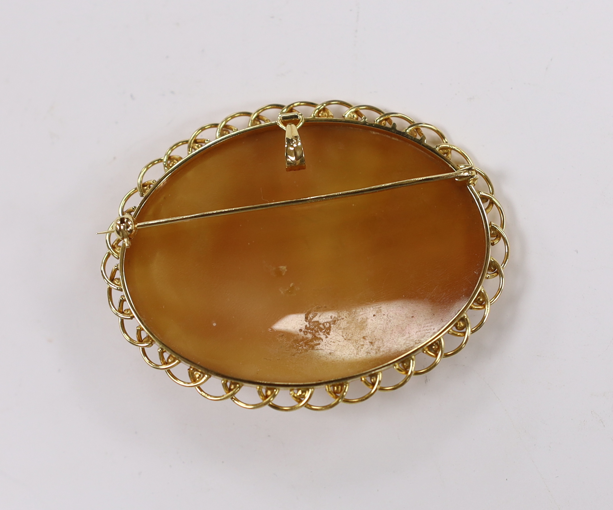 A modern 18k mounted oval cameo shell pendant brooch, carved with Phoebus and the hours preceded by Aurora, 58mm, gross weight 16 grams.